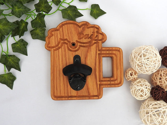 Wooden bottle opener shaped like a beer glass tankard mug with 'Dad' text, surrounded by decorative elements on a white background.